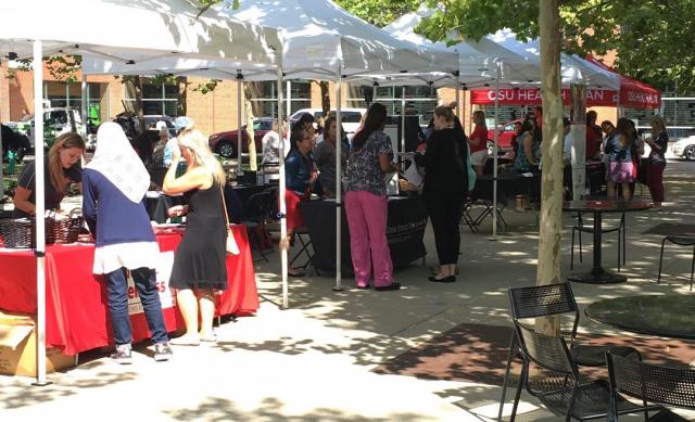 People chatting at the vendor booth at the 2018 Ohio State Farmer's Market