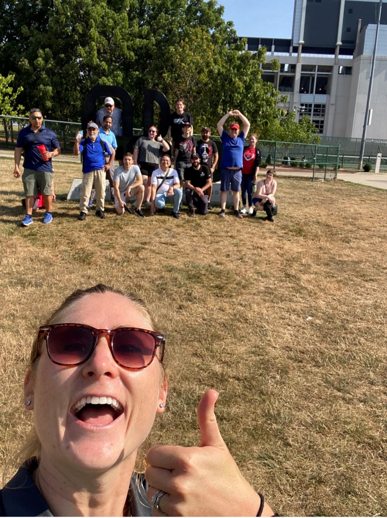 Staff members on a walk with Ashley Richardson, who is giving a thumbs up. 