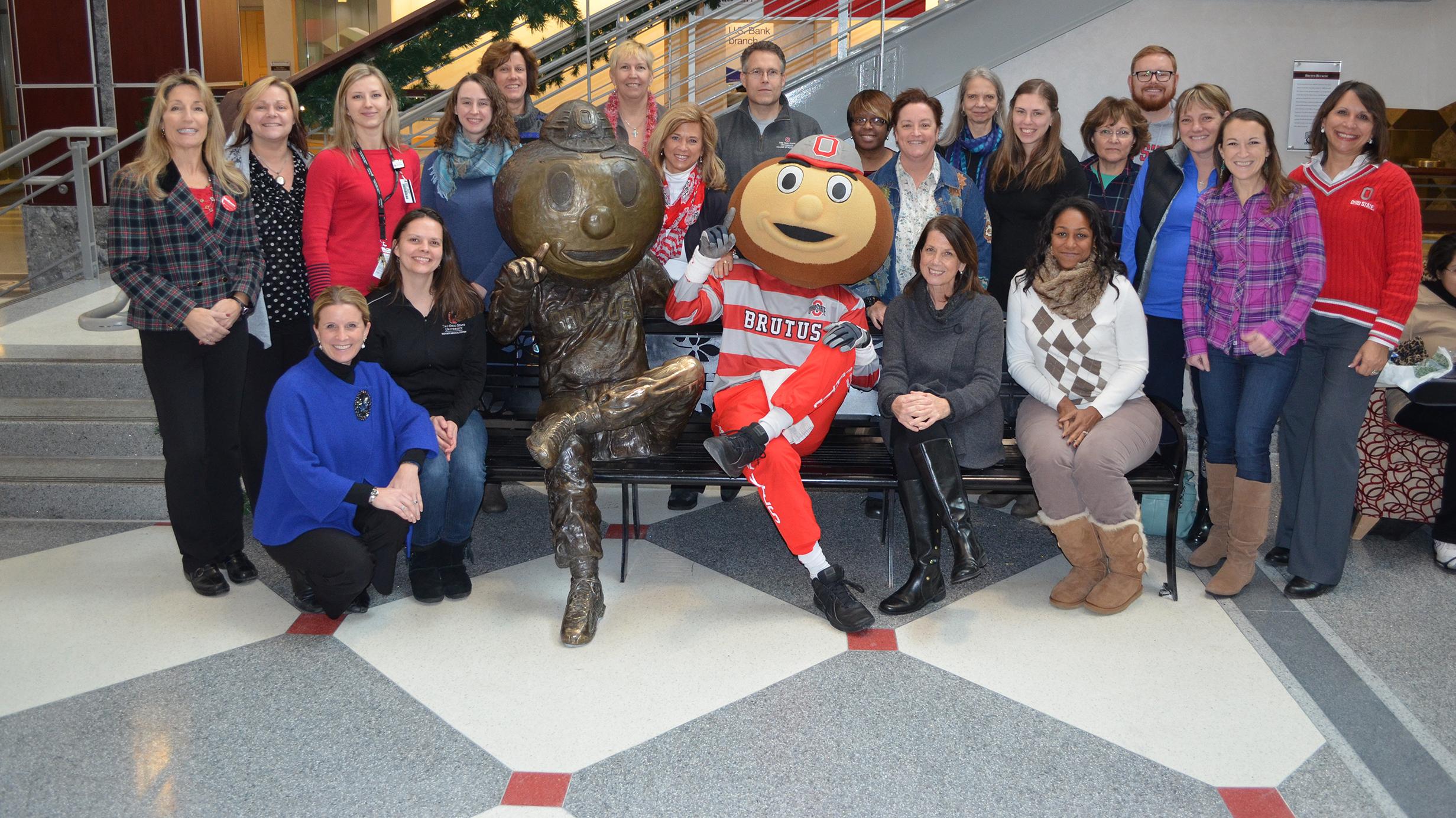 Buckeye Wellness Innovators pose with Brutus Buckeye next to the Brutus Buckeye bench statue in the Ohio Union.