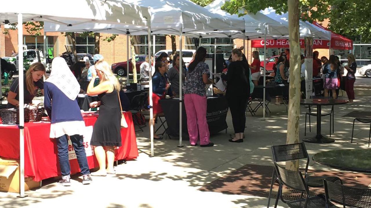 People chatting at the vendor booth at the 2018 Ohio State Farmer's Market